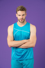 Proud to be strong. Man sporty outfit looks serious and strict with folded arms, violet background. Guy muscular body proud of his shape. Sportsman enjoy his muscular body proud of himself