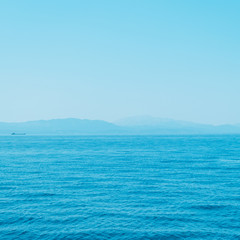 alien mountain landscape and sea. bright neon blue colors. minimal and surreal. summer vacation.