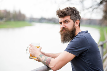 Man with long beard looks relaxed. Man with beard and mustache on calm face, river background,...