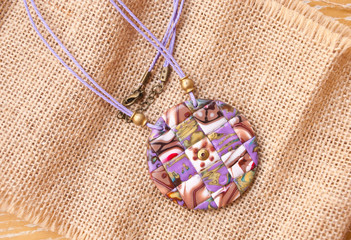 Mosaic lavender gold pendant. Handmade necklace from polymer clay. Fashion background.