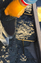 worker while splitting the concrete with the jackhammer during the renovation of a roof