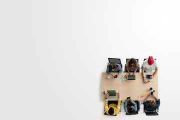Top view of diverse people of creative team group using smartphone, tablet and computer laptop. Overhead of asian young creative start up meeting. Have copy space for fill text
