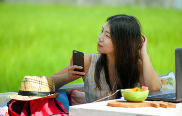 young beautiful and happy Asian Korean digital nomad woman working relaxed outdoors at coffee shop...