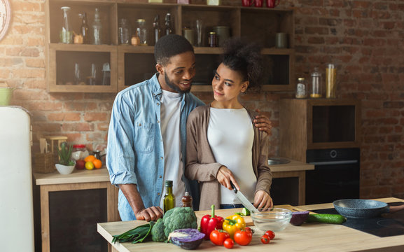 Loving african-american couple cooking in loft kitchen