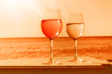 Two glasses by sea in orange