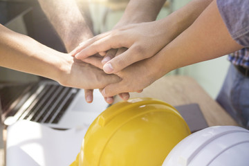 teamwork concept engineers and worker put hand on together on working table for powerful working