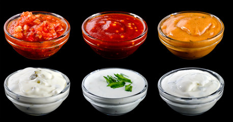 Set of different delicious sauces for dishes isolated on black b