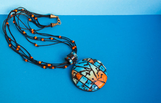 Beautiful bright pendant necklace blue, orange, black. Hanmade jewelry from polymer clay. Fashion trend jewelry.
