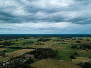 Fototapeta na wymiar drone image. aerial view of rural area with houses and roads under heavy and dark dramatic rain clouds in summer day. night photo