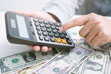 close up businessman hand using a calculator to calculate the numbers expenses. finance accounting saving money concept.