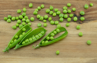 Fresh harvest green peas and pea pods from my garden on wooden  background 