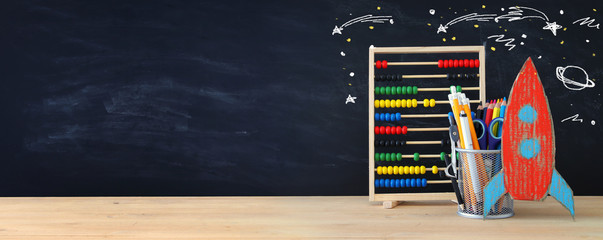 Back to school concept. rocket and pencils in front of classroom blackboard.