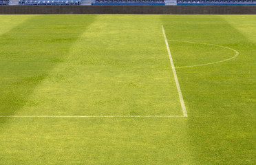 green grass from football field, soccer field with shadow of grandstand