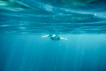 Man swimming in the blue ocean