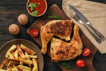 Roasted chicken legs with fried potatoes and tomato dip.