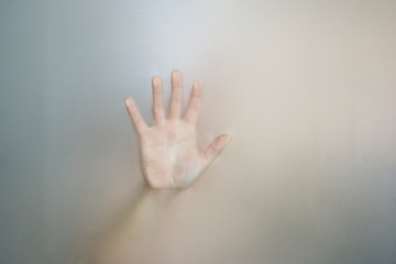 Female hands behind the glass in the bathroom.