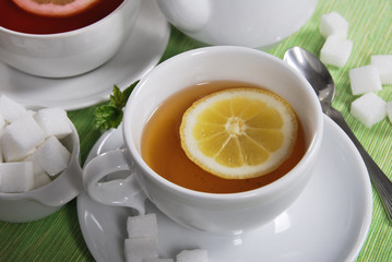 herba with lemon in a white cup with sugar cubes