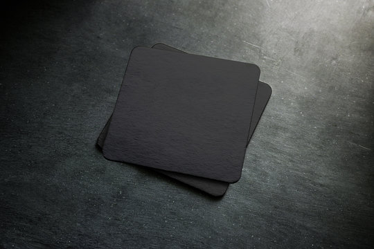 Blank black beer coaster stack mock up, top view, lying on the textured background. Squared clear can mat design mockup isolated. Quadrate cup rug display