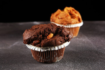 Chocolate muffin and nut muffin, homemade bakery on dark background.