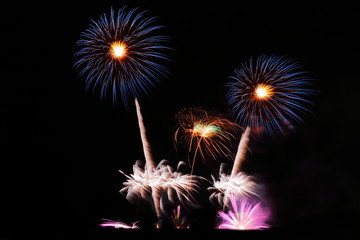 Festive colorful fireworks on night sky background. Celebratory holiday