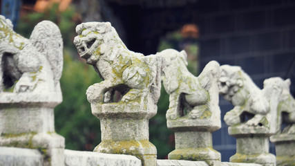 Closeup Shot at Vintage Stone Lion Miniature Sculptures, Decorated on East Asian Style Fence or Terrace of A Chinese Historical Place in China.  Selective Focus and Blurred Background.