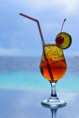 Colorful juice beverage against blue sea