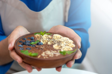 Selected focus on women hand hold a spoon with healthy food on white table. Healthy women eating cereal and fresh fruits for dieting.