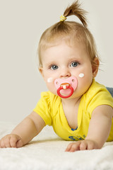 Studio portrait of adorable baby girl with cream on her cheeks
