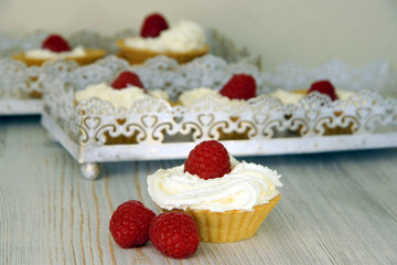 Ready-made cakes with cream and red raspberries
