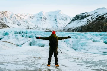 Foto auf Acrylglas Gletscher abenteuerlustiger Mann, der auf einem Gletscher in Island geht