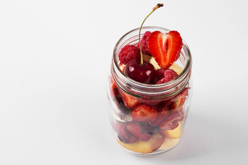 Various fruits and berries in a glass jar. Concept meals to go