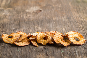 Healthy snack. Tasty dried apple rings chips on wooden backgroun