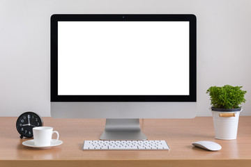 All in one computer, mouse, keyboard, coffee cup and plant vase  on wooden table