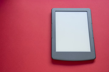 E-book on a red background with free space top view