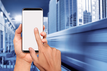 Hand Holding Smart phone with downtown Sky Train blurry background