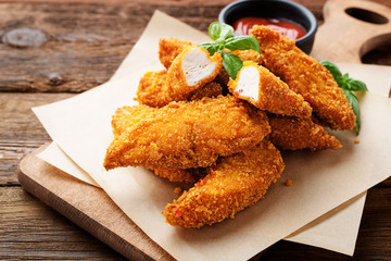 Delicious crispy fried breaded chicken breast strips with ketchup. - 210698830