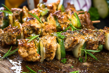Grilled meat and vegetable skewers on wooden board
