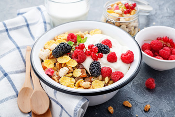 Healthy breakfast. Fresh granola, muesli with yogurt and berries on gray background. Top view. Copy space.
