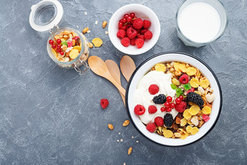 Healthy breakfast. Fresh granola, muesli with yogurt and berries on gray background. Top view. Copy space.