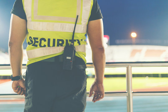 Back of security standing in the soccer stadium. - Powered by Adobe