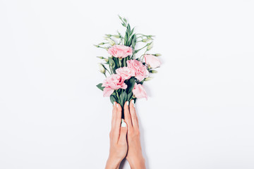 Woman's hands with trendy manicure holding bunch of pink flowers