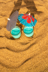 Fototapeta na wymiar colorful shots drinks on a sandy beach with umbrellas for drinks