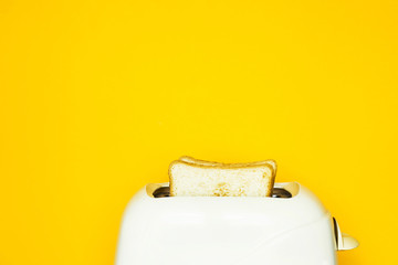 Toasted bread sticks out of the toaster on a yellow background. Pop Art. Copy space