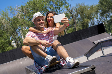 Happy young couple having fun in the skate park