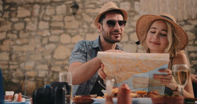 Tourists reading map and planning route at European rustic restaurant