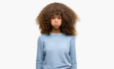 African american woman wearing a sweater puffing cheeks with funny face. Mouth inflated with air, crazy expression.