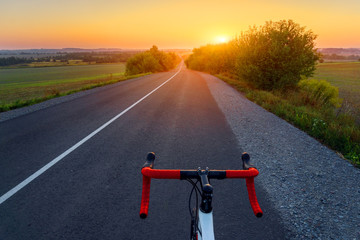 Bicycle on a road. Beautiful sunset landscape with road bike