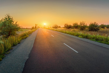 Beautiful rural asphalt road sunset landscape.