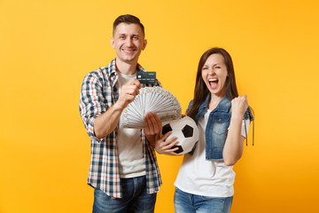 Young win couple, woman man, football fans holding bundle of dollars money, credit card, soccer...