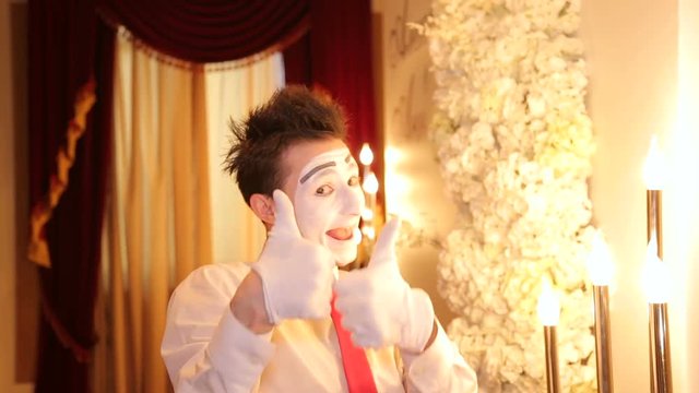 A mime artist shows the pantomime making a heart shape out of the hands. Comedian. Mime is an artist.